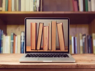 Image of a laptop with books on screen