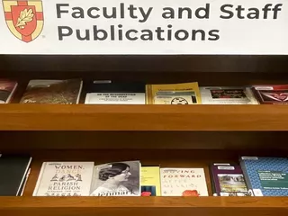 Image showing a bookcase labeled "Faculty and Staff Publications"